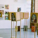 art display of boxes on stands with painted faces.